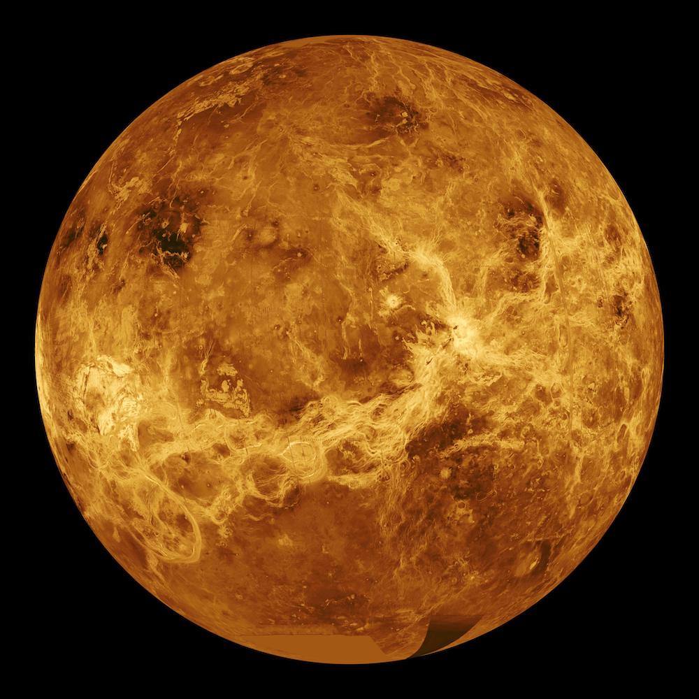 Detailed photo of the planet Venus. Golden, orange, and brown tones. Black background.