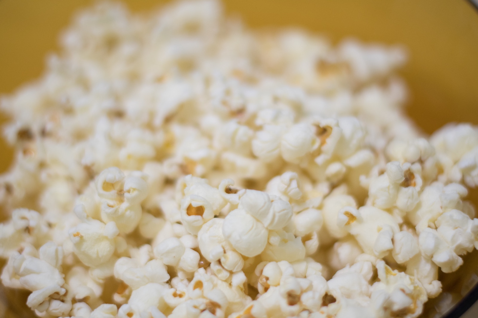 Macro up-close photo of popcorn kernels that have been cooked.